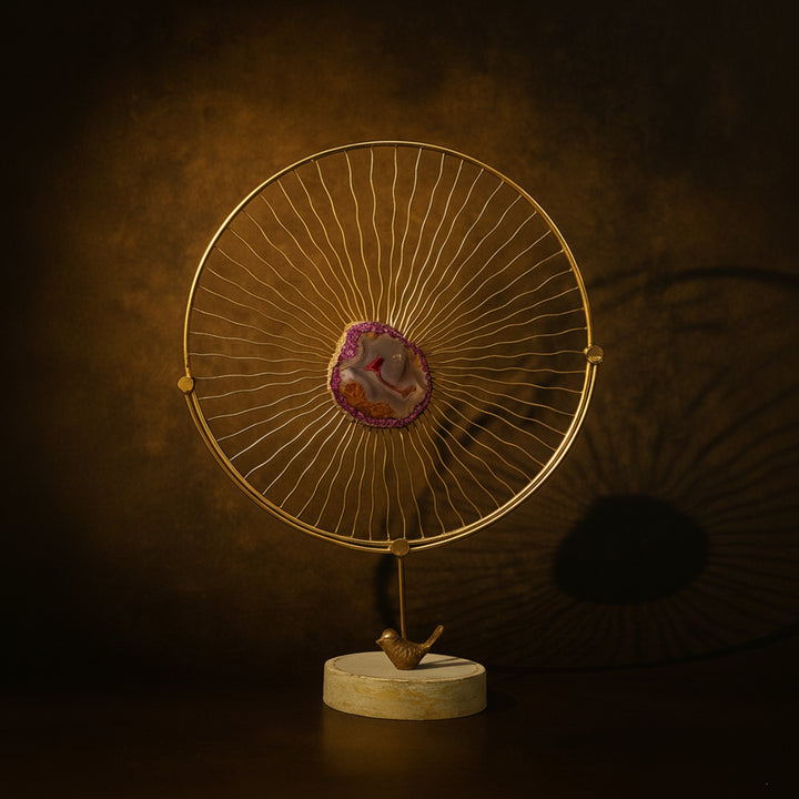 Golden circular metal decor piece with a purple geode stone center and a bird base on marble stand, luxury home decor by Divoma.Also for diwali decoration