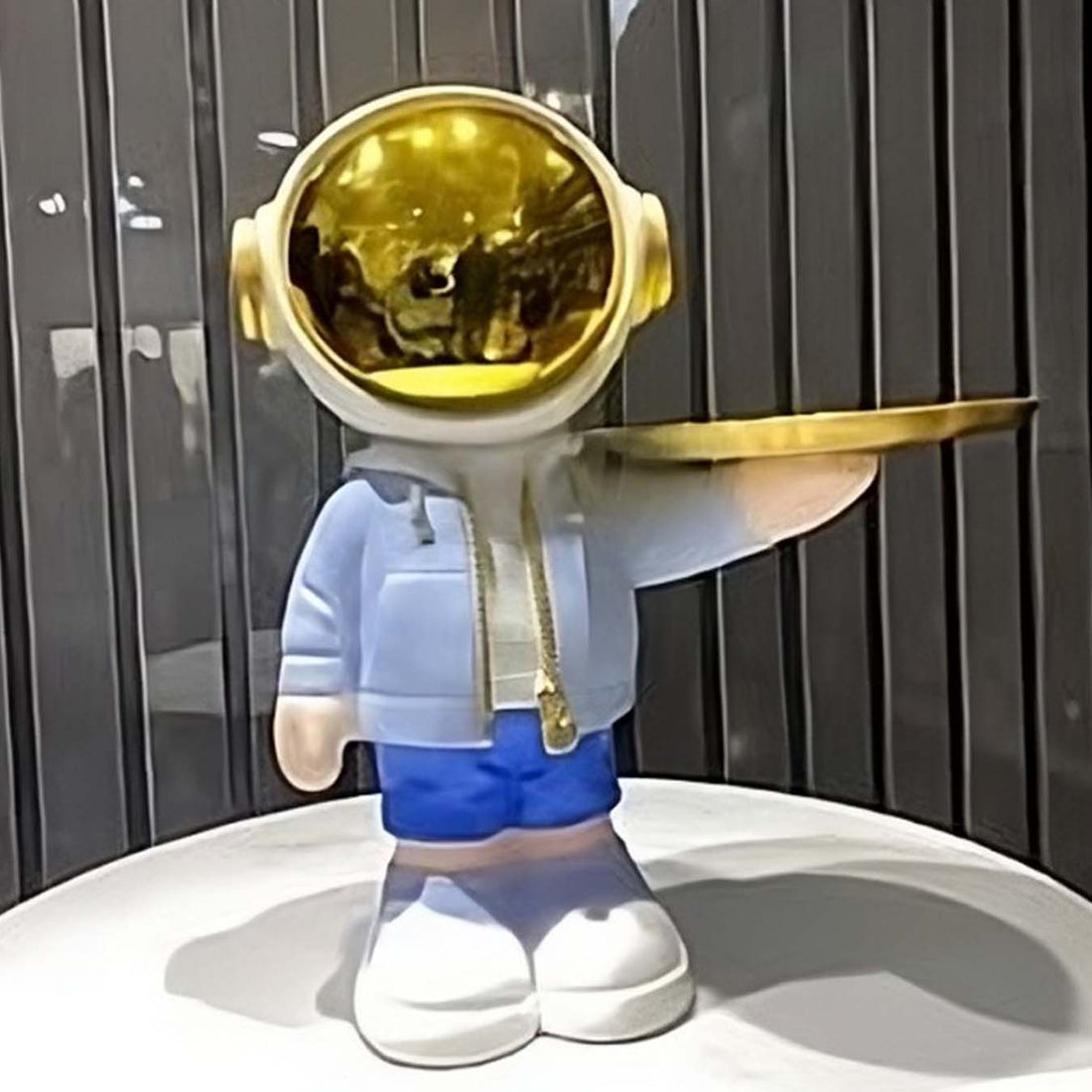 Astronaut figurine holding a gold tray for home decor