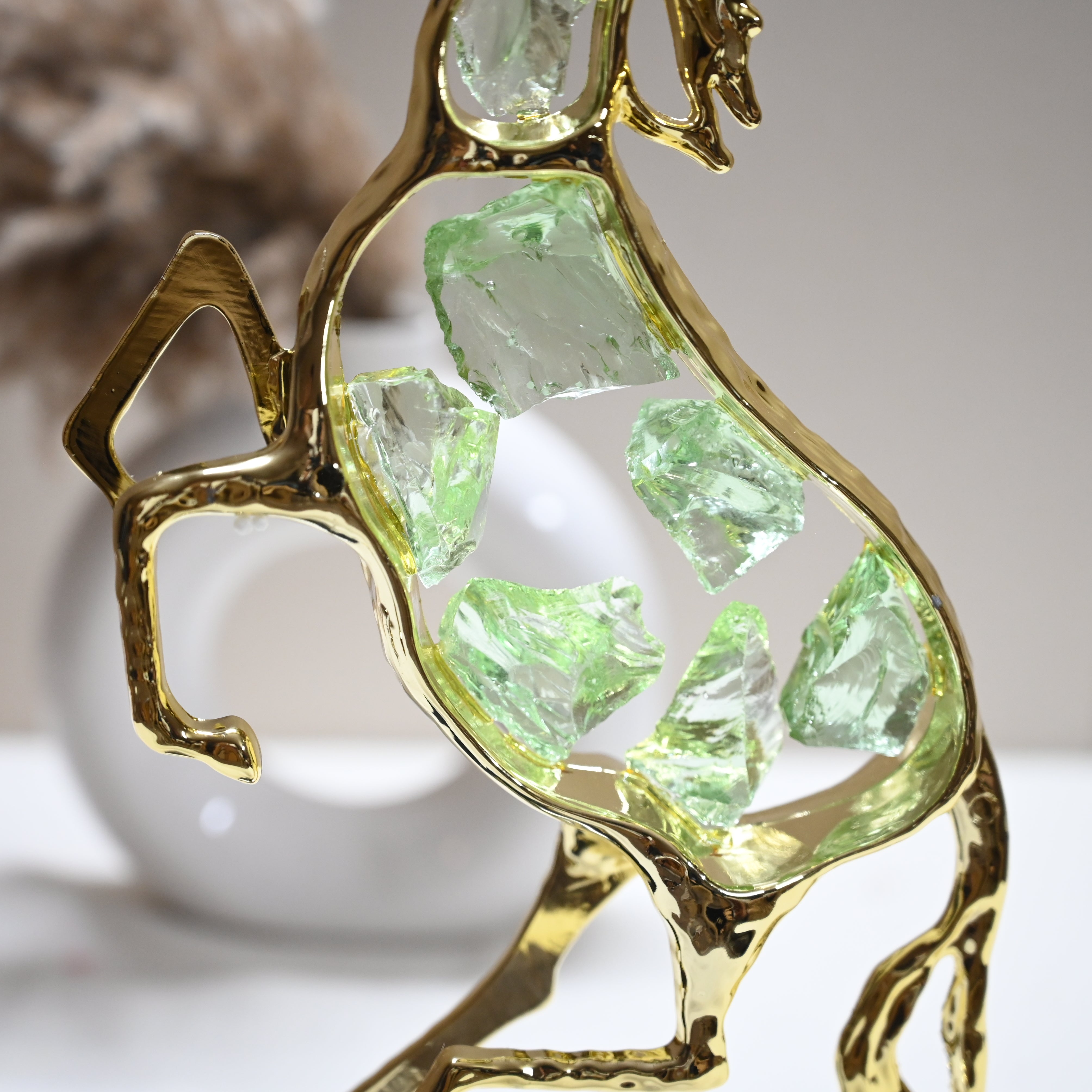 Elegant gold horse figurine with geometric green gemstone details