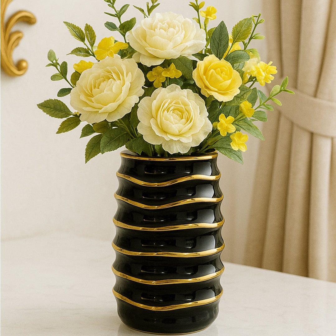 Black ceramic vase with gold wave detailing, placed on a marble table in a luxury interior.